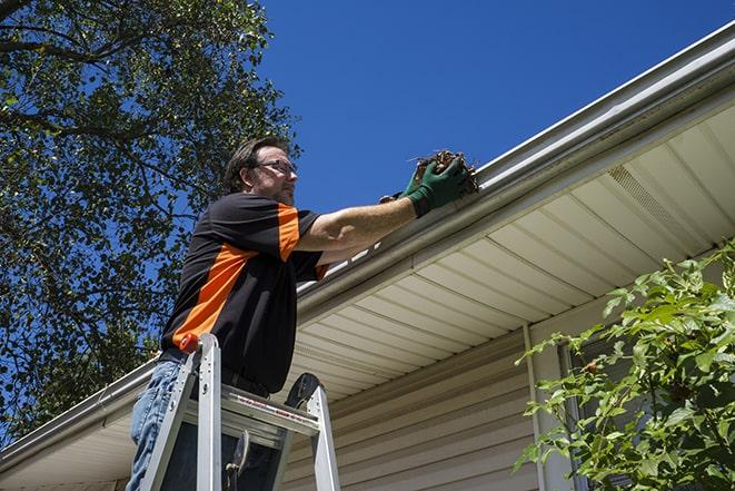 a worker conducting maintenance on a gutter in Ceres, CA